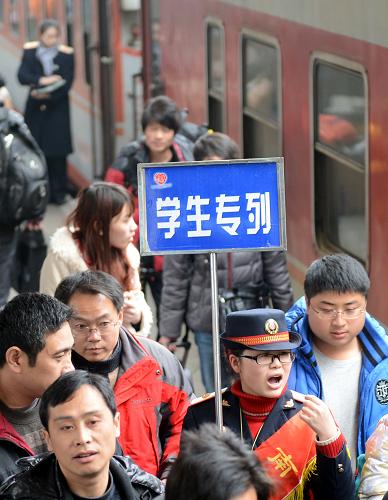 1月16日,南昌火車站一名工作人員手舉指示牌引導(dǎo)學(xué)生旅客進(jìn)站上車。當(dāng)日,為方便高校學(xué)生順利返鄉(xiāng),南昌火車站開出2013年寒假首趟學(xué)生專列。該專列是南昌至蘭州的L1026次列車,途經(jīng)武昌、鄭州、洛陽(yáng)、三門峽西、西安、寶雞、天水等主要城市。新華社記者 周科 攝