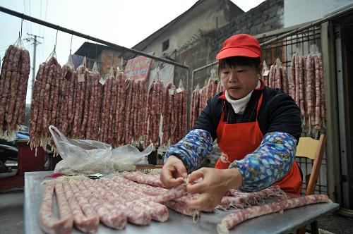 1月19日,在廣西南寧市水街,一名工人在加工臘腸準(zhǔn)備供應(yīng)年貨市場。隨著農(nóng)歷新年的臨近,廣西南寧市各商家正在緊張加工傳統(tǒng)臘腸、臘肉等臘味年貨,供應(yīng)日益熱鬧的年貨市場。臘味深受廣西各族同胞喜愛,逢年過節(jié)更是宴席上不可或缺的食品。新華社記者 陸波岸 攝