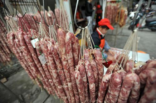 1月19日,在廣西南寧市水街,一名工人在加工臘腸準(zhǔn)備供應(yīng)年貨市場。新華社記者 陸波岸 攝