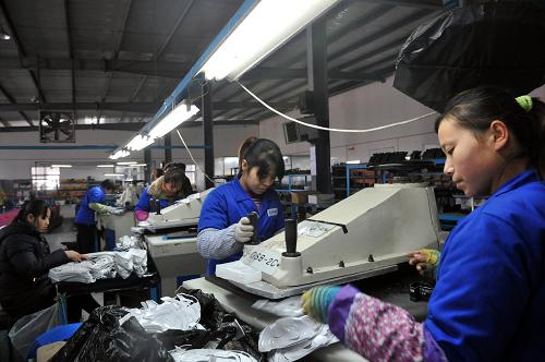 無棣一家鞋業(yè)的工人利用自建的光伏電源加工旅游鞋(1月18日攝)。新華社記者 范長國 攝