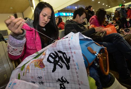 1月27日,25歲的龔平輝在杭州火車站候車準備回老家陜西時繡十字繡。在浙江義烏做外貿(mào)工作的她說:“不管身在何處,家始終是牽著你的那條線。”新華社記者 韓傳號 攝