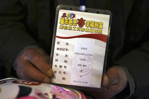 2月2日,乘坐D5206次農(nóng)民工免費專列的紀洪兵在展示乘車牌。他告訴記者:“這是我第一次坐動車,以前都是坐普通火車回家過年,根本沒想到能坐上農(nóng)民工專列,不僅免費,還是動車。”新華社發(fā)(全亞軍 攝)