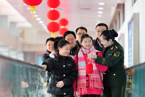 2月12日,在福州馬尾客運(yùn)旅檢大廳,邊檢警官(右一)為旅客們送上小紅燈籠。當(dāng)日是大年初三,“兩馬”航線共驗(yàn)放169名出入境旅客,迎來(lái)春運(yùn)客流的小高峰。據(jù)福州邊檢站介紹,春運(yùn)期間,“兩馬”航線客流量比平常上升50%,為應(yīng)對(duì)客流量激增,福州邊檢站通過(guò)警務(wù)微博發(fā)布天氣、出行和乘船提示,并推出“母嬰快速通道”“特殊人員免排引導(dǎo)”等服務(wù),確保返鄉(xiāng)旅客及時(shí)通關(guān)。“兩馬”客運(yùn)航線2013年春運(yùn)時(shí)間為1月26日至3月6日,共40天。新華社記者魏培全攝