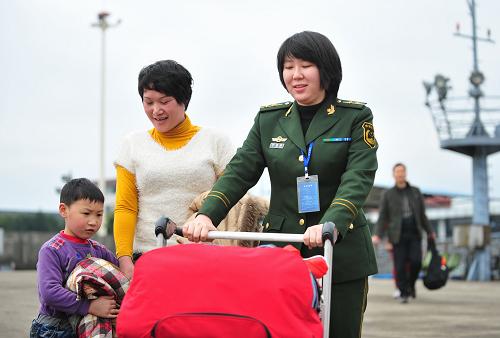 2月12日,在福州馬尾客運(yùn)碼頭,邊檢警官為旅客推行李。新華社記者魏培全攝