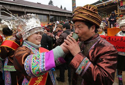 2月21日,在廣西融水苗族自治縣安太鄉(xiāng)林洞村大寨屯,一名苗家女向前來(lái)“打同年”的客人敬酒。新華社發(fā)(龍濤 攝)