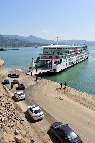 4月6日,在三峽大壩上游湖北省秭歸縣銀杏沱客運滾裝碼頭,小型客車等待登上“中堡島”號旅游滾裝客船。日前,長江三峽庫區(qū)滾裝旅游船投入運營。滾裝旅游船通航后,游客可連人帶車登上滾裝游船,先乘船飽覽江上美景,再自駕游陸上景點。這意味著長江三峽旅游從此實現(xiàn)水上游和自駕游的“無縫對接”。三峽庫區(qū)首批滾裝旅游客船由湖北宜昌一家旅游企業(yè)打造,目前主要開通宜昌至奉節(jié)之間往返航班。滾裝游船途經(jīng)巫山、巴東等地,航程比從宜昌直接駕車到奉節(jié)縮短140多公里。新華社發(fā)(王輝富 攝)