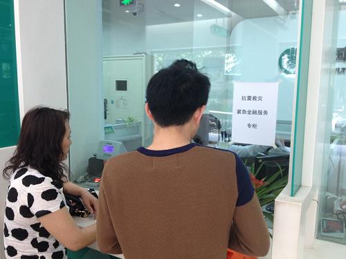 4月20日,顧客在中國農(nóng)業(yè)銀行四川雅安分行抗震救災緊急金融服務專柜辦理業(yè)務。新華社發(fā)