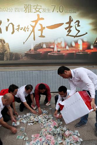 4月21日,深圳市喜德盛自行車有限公司工作人員在清點(diǎn)捐款。該公司為四川蘆山地震災(zāi)區(qū)捐款527746.6元。新華社發(fā)(陳雷 攝)