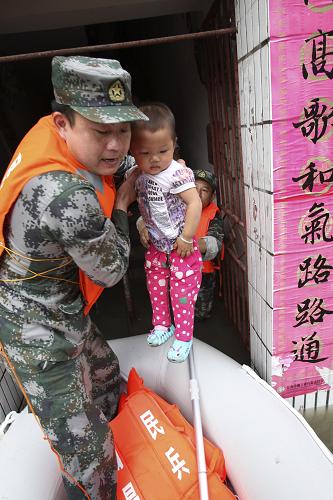 5月15日,江西省南昌市青云譜區(qū)人武部民兵將一名受困的小朋友轉(zhuǎn)移至安全地帶。新華社發(fā)(朱文標(biāo) 攝)