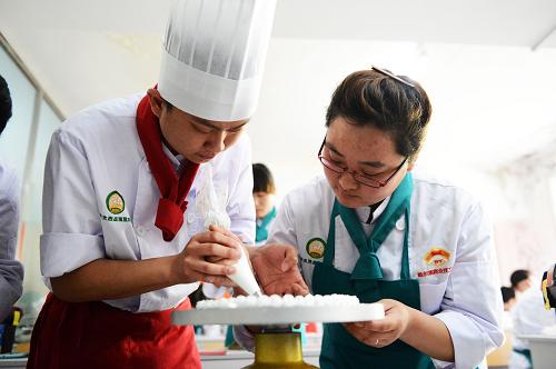 5月15日,一名殘疾學(xué)員(右)在殘疾人糕點(diǎn)制作師的指導(dǎo)下制作蛋糕。以培訓(xùn)促就業(yè)是目前殘疾人扶貧助殘工作的主要方向之一。哈爾濱市殘疾人就業(yè)服務(wù)指導(dǎo)中心從2010年起開(kāi)設(shè)殘疾人訂單式糕點(diǎn)培訓(xùn),采取政府掏錢(qián),殘疾人免費(fèi)學(xué)習(xí)的方式,每年為30名殘疾人提供去糕點(diǎn)企業(yè)學(xué)習(xí)技術(shù)的機(jī)會(huì),技能優(yōu)秀的殘疾人直接被糕點(diǎn)企業(yè)聘用。自2010年以來(lái),該項(xiàng)目共培訓(xùn)100多名殘疾人,其中60多人成功就業(yè)或創(chuàng)業(yè)。新華社記者 王凱 攝