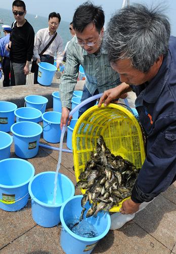 6月8日,漁民代表在準(zhǔn)備放流的魚苗。新華社記者 李紫恒 攝