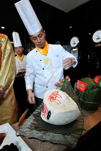 6月8日,在太原市長(zhǎng)治路一家飯店,廚師將售價(jià)9999元的粽子裝盤。端午節(jié)臨近,太原市長(zhǎng)治路一家飯店向社會(huì)推出一款用松露、鮑魚(yú)、泰國(guó)香米等食材制成粽子,其單個(gè)售價(jià)高達(dá)9999元人民幣,在太原市民中引起廣泛的爭(zhēng)議。新華社記者 詹彥 攝