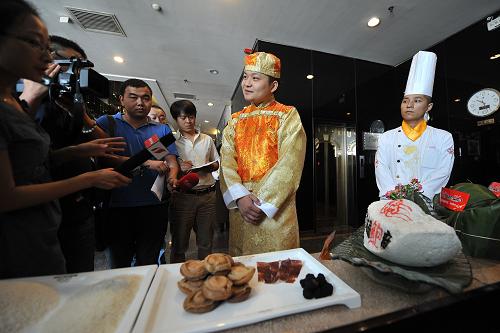 6月8日,推出“天價(jià)”粽子的飯店工作人員在接受記者采訪。據(jù)了解,該店目前已預(yù)訂出了15個(gè)“天價(jià)”粽子。新華社記者 詹彥 攝