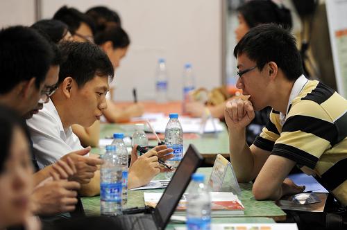 6月8日,一位高校畢業(yè)生求職者(右)在一家用人單位的攤位前面試求職。當(dāng)日,2013年浙江省高校畢業(yè)生就業(yè)招聘大會在杭州和平國際會展中心舉行。此次招聘會共有全省1350余家企事業(yè)單位參加,面向高校畢業(yè)生推出各類就業(yè)崗位2.5萬余個。新華社記者 鞠煥宗 攝