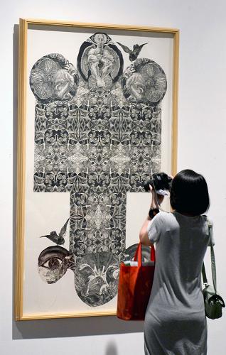 7月6日,觀眾在“2013臺中市大墩美展文化交流展”上欣賞版畫作品《警世語錄》。新華社發(fā)(施健學 攝)