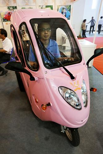 7月6日,觀眾在車展上試乘一款電動(dòng)三輪車。新華社發(fā)
