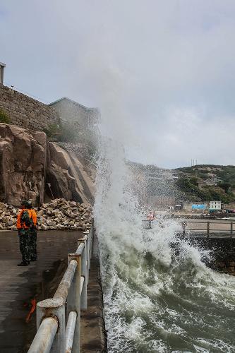 7月12日,在浙江省舟山市東極鎮(zhèn)廟子湖島,海邊掀起巨浪。東極邊防派出所官兵加強(qiáng)警戒,嚴(yán)防游客接近危險(xiǎn)區(qū)域。新華社記者 徐昱 攝