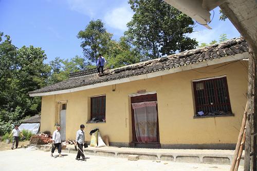 7月22日,甘肅省隴南市成縣城關(guān)鎮(zhèn)北山村村民在清理受損的房脊碎片。新華社發(fā)(吳庭棟 攝)