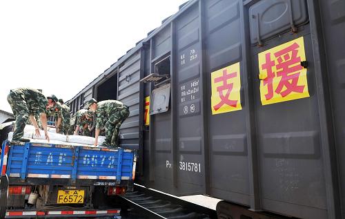 7月23日,武警官兵在往救災(zāi)專列上裝運(yùn)帳篷。新華社記者 王建威 攝