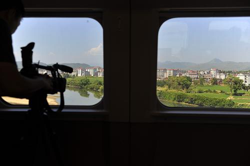 8月9日,一名攝像記者在向莆鐵路聯(lián)調(diào)聯(lián)試檢測(cè)車內(nèi)拍攝車窗外的風(fēng)景。新華社記者 魯鵬 攝