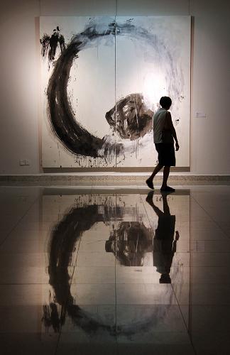 8月13日,一名參觀者經(jīng)過展出的作品。新華社發(fā)(仲夢(mèng)麗 攝)