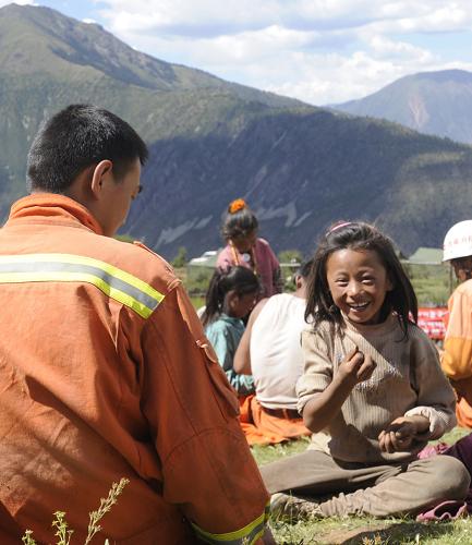 昌都地震災(zāi)區(qū)的孩子與武警消防官兵在一起玩扔石頭游戲(8月16日攝)。新華社記者 拉巴次仁 攝