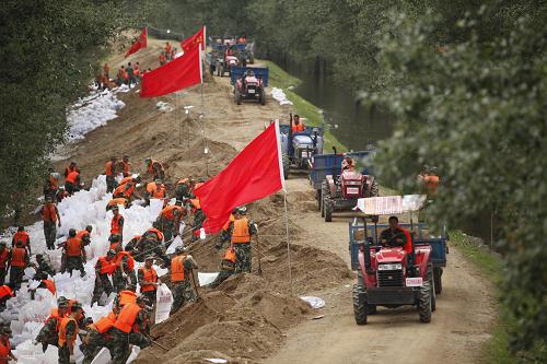 武警某部官兵在黑河市遜克縣干岔子鄉(xiāng)加固黑龍江大壩(8月17日)。新華社發(fā)(郝長(zhǎng)波 攝)