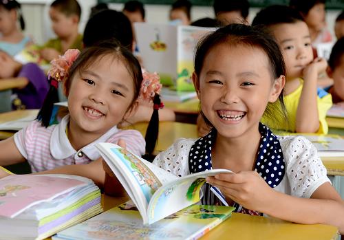 9月2日,在閩侯縣余盛小學(xué)就讀一年級的江西籍外來農(nóng)民工子女胡可怡(右)高興地領(lǐng)到免費的新課本。當日是新學(xué)期開課第一天,福建省閩侯縣糾風(fēng)辦會同縣審計、物價等部門,對全縣義務(wù)教育階段學(xué)校零收費政策落實情況進行檢查,確保教育“惠民工程”落到實處。近年來,閩侯縣全面推行教育“惠民工程”,實行義務(wù)教育階段“三免一補”政策;對寄宿生免除住宿費,并補助周末返家交通費。2012年以來,全縣共投入教育經(jīng)費12億元,惠及全縣9萬多名學(xué)生,其中外來農(nóng)民工子女1.2萬多人。新華社記者 張國俊 攝