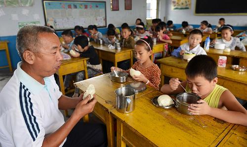 9月4日,張偉和四年級三班的學(xué)生一起在教室吃午飯。新華社發(fā)(董乃德 攝)