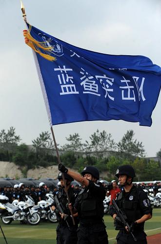 9月6日,“藍(lán)鯊”突擊隊(duì)隊(duì)員在出警儀式上高舉旗幟。新華社發(fā)(姜冰 攝)