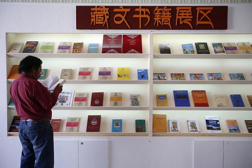 9月15日,讀者在2013北京國際圖書節(jié)藏文書籍展區(qū)閱讀圖書。新華社發(fā)(趙冰 攝)
