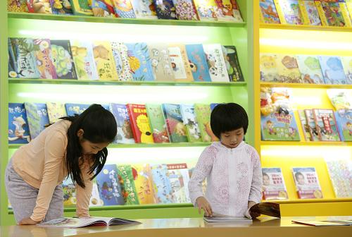 9月15日,兩名小朋友在2013北京國際圖書節(jié)上翻閱兒童讀物。新華社發(fā)(趙冰 攝)