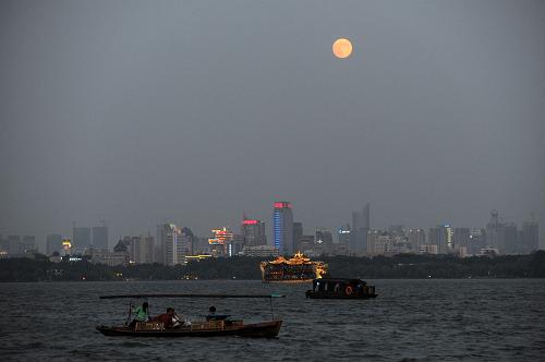 9月19日,一輪圓月升起在杭州西湖上空。新華社記者 鞠煥宗 攝