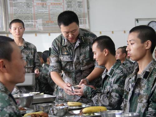 9月19日,北京衛(wèi)戍區(qū)某警備團新兵一連指導員謝舟給當天過生日的新兵孫闖端來了“長壽面”。新華社發(fā)(李培斌 攝)