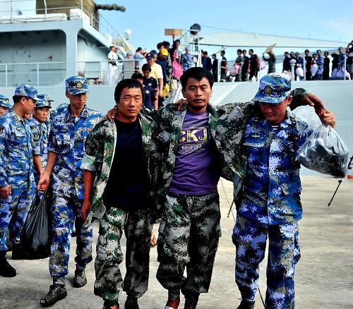 10月3日,子弟兵攙扶著受傷漁民走下軍艦。新華社記者 張永峰 攝
