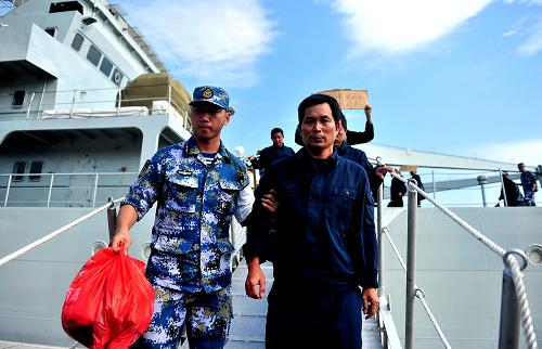10月3日,一位子弟兵攙扶著一位漁民走下軍艦。新華社記者 張永峰 攝