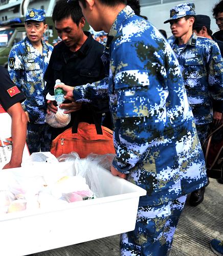 10月3日,子弟兵分發(fā)礦泉水和面包給獲救漁民。新華社記者 張永峰 攝