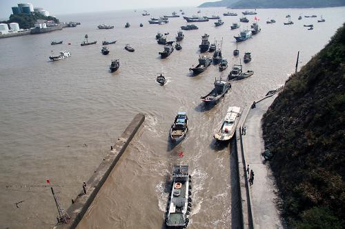 10月5日,浙江臺州市路橋區(qū)金清新閘外海的大批漁船進閘回港避臺風。 中央氣象臺當日發(fā)布臺風紅色警報:今年第23號強臺風“菲特”將于5日下午到夜間進入東海東南部海面,以后逐漸向浙閩沿??拷?,并將于6日晚上到7日上午在浙江中部到福建北部沿海登陸。受“菲特”和冷空氣的共同影響,5日8時至6日8時,東海大部海域、浙江沿海及杭州灣將有7至9級大風,其中臺灣以東洋面和東海東南部的部分海域風力有10至12級。浙江省舟山市邊防、漁政、海事等部門緊急組織人員深入港口、碼頭一線,引導船舶有序???,協(xié)助漁民做好各項防臺風準備工作。新華社發(fā)(梁敏慧 攝)