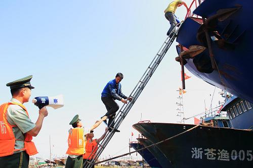 10月5日,浙江溫州公安邊防支隊官兵在蒼南舥艚漁港幫助漁民轉(zhuǎn)移,防范強臺風“菲特”。新華社發(fā)(蔡寬元 攝)