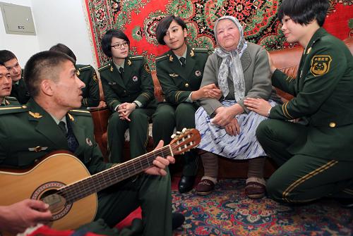 10月13日,武警邊防部隊烏魯木齊指揮學校的學員們?yōu)楣鹿牙先税⒁雷文竞?#183;艾依蓋爾(右二)表演自己編排的節(jié)目。當日,武警邊防部隊烏魯木齊指揮學校的學員們來到烏魯木齊天山區(qū)大灣北路76歲的孤寡老人阿依孜木汗·艾依蓋爾和身患尿毒癥的77歲老人楊秀蓮家,與老媽媽們共同歡度重陽節(jié)。學員們?yōu)槔先怂蛠砹斯?jié)日禮物,表演了文藝節(jié)目。新華社記者 趙戈 攝