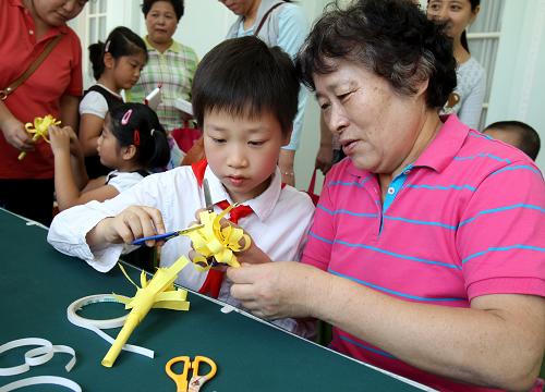 10月13日,10歲的鄒彥祺和外婆顧慶華一起制作“重陽菊”。當日是中國傳統(tǒng)的重陽節(jié),“老少重陽 別樣隊日——上海市青少年傳統(tǒng)文化感知行重陽節(jié)特別活動”在中福會少年宮舉行。孩子們與爺爺奶奶、外公外婆一起參加隊日活動,開展親子游戲,在其樂融融中感受重陽節(jié)的傳統(tǒng)內涵,懂得“愛老”、“敬老”的責任。新華社記者 劉穎 攝