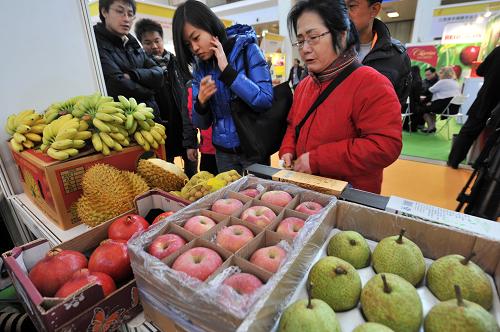11月28日,觀眾在展覽會(huì)上觀看來自泰國(guó)的水果。新華社發(fā)(王京生 攝)