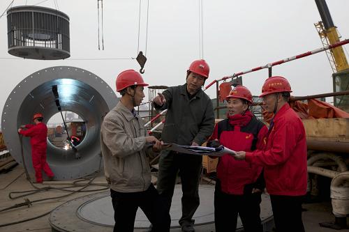 我國(guó)首座深水電力引水隧道貫通 工程技術(shù)人員現(xiàn)場(chǎng)辦公,最后一次審定取水立管的對(duì)接方案,以確保施工準(zhǔn)確無(wú)誤(12月7日攝)。 12月8日,隨著最后一根高12米、重17噸的鋼質(zhì)取水管在深達(dá)22米的長(zhǎng)江底部焊接成功,中國(guó)鐵建十四局集團(tuán)承建的我國(guó)首座深水電力引水項(xiàng)目——江蘇常熟電廠引水隧道全面貫通。這一隧道工程整體偏差僅7厘米,標(biāo)志著我國(guó)復(fù)雜地質(zhì)條件下特殊結(jié)構(gòu)引水隧道的設(shè)計(jì)、施工與科研取得重大突破。新華社發(fā)(劉渝 攝)