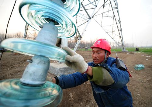 12月10日,在安徽省阜陽市潁東區(qū)蘇集鄉(xiāng),國家電網(wǎng)安徽送變電工程公司的施工人員在進(jìn)行架線作業(yè)。新華社發(fā)(鄭賢列 攝)