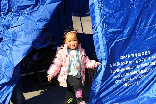 12月17日,湖北巴東縣東瀼口鎮(zhèn)石板村一名女童在救災(zāi)帳篷門口玩耍。新華社記者 郝同前 攝