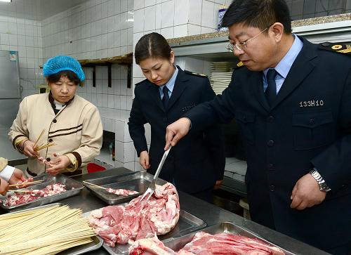 12月18日,秦皇島市海港區(qū)食品稽查大隊(duì)的執(zhí)法人員在檢查一家燒烤店的原料。新華社記者 楊世堯 攝