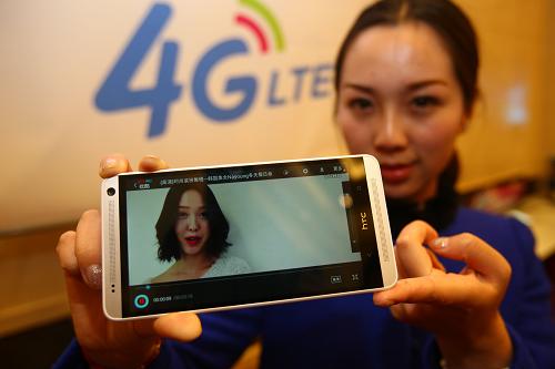 12月18日,浙江省的杭州、寧波、溫州三市正式開辦中國(guó)移動(dòng)4G業(yè)務(wù)。這是在寧波舉行的移動(dòng)4G商業(yè)運(yùn)營(yíng)儀式上,一位女士展示4G手機(jī)上網(wǎng)播放的視頻。新華社發(fā)(張培堅(jiān) 攝)