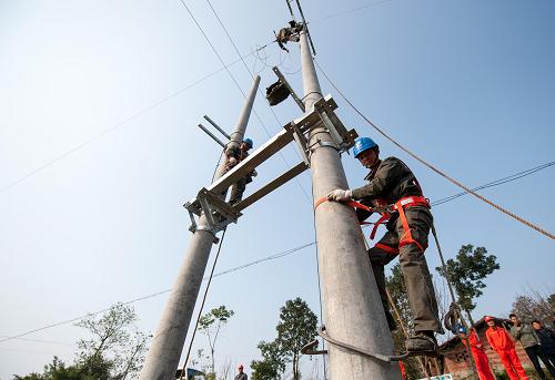 12月20日,國(guó)家電網(wǎng)重慶綦南供電公司的兩名電力職工爬上電線桿為綦江區(qū)三角鎮(zhèn)徐家村進(jìn)行農(nóng)村電網(wǎng)升級(jí)改造。新華社記者 劉潺 攝