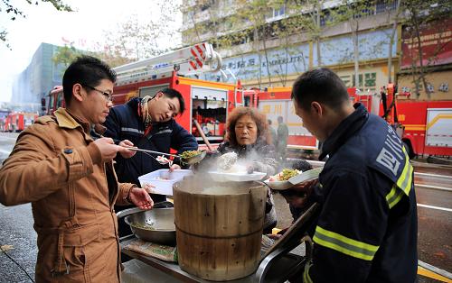 12月27日,四川瀘州江陽區(qū)摩爾瑪商場天然氣爆燃事故發(fā)生后,市民自發(fā)為救援人員送來飯菜。新華社發(fā)