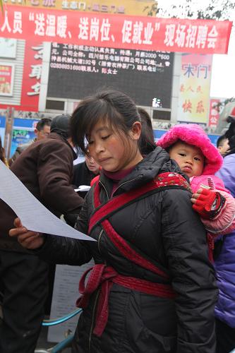 1月24日,一名返鄉(xiāng)農(nóng)民工在四川省眉山市青神縣舉行的招聘會上了解企業(yè)招聘信息。新華社發(fā)(姚永亮 攝)